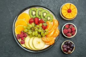 top view different fruits composition fresh and sliced fruits on dark background health fresh fruit